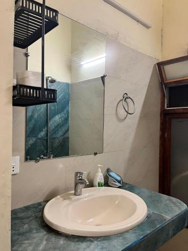 a bathroom with a sink and a mirror at Rooms In Central Rawalpindi in Rawalpindi