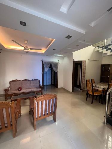 a living room with wooden chairs and a table at The 9th Oasis in Hyderabad