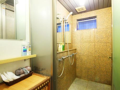 a bathroom with a shower with a glass door at Ryokan Kamogawa Asakusa in Tokyo