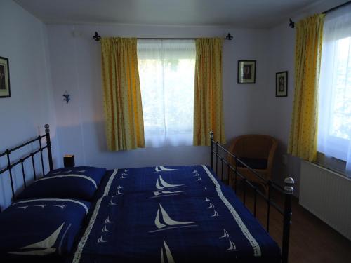 a bedroom with a bed with blue sheets and a window at Haus am Burgberg in Frankenberg