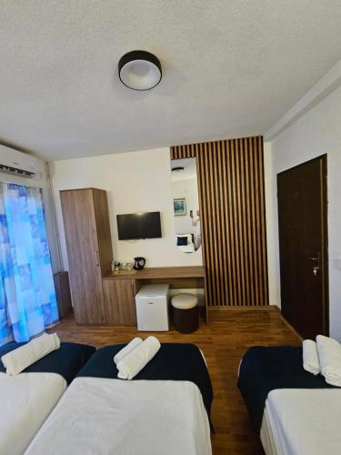 a hotel room with three beds and a flat screen tv at VN APARTMENTS OHRID in Ohrid