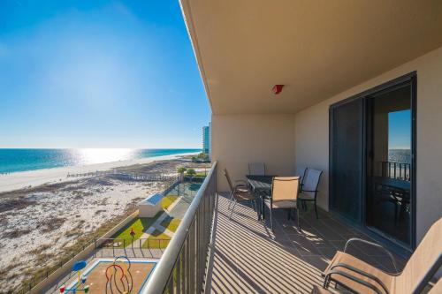 a balcony with a table and chairs and the beach at Phoenix X 504 in Orange Beach
