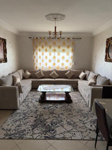 a living room with a couch and a table at Appartement moderne - Résidence privée in Kenitra