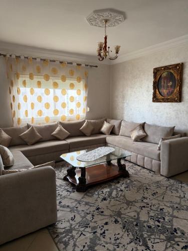 a living room with a couch and a table at Appartement moderne - Résidence privée in Kenitra