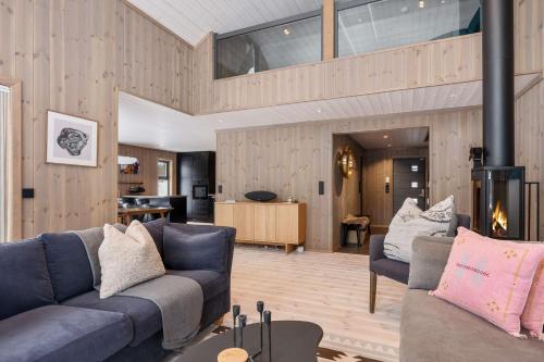 a living room with two couches and a kitchen at TH2124- Spacious ski-in out cabin in Trysilfjell with 5 bedrooms in Hovi