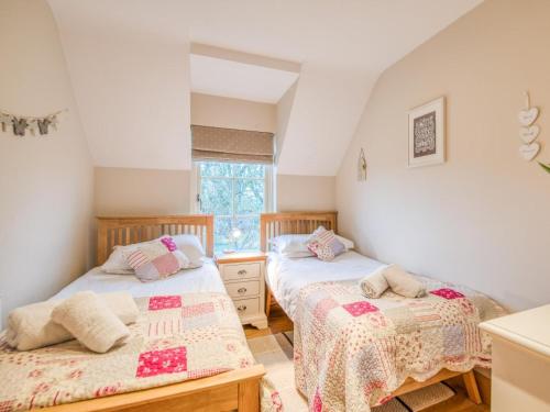 two twin beds in a room with a window at 2 Bed in Chathill oc-77990 in Ellingham