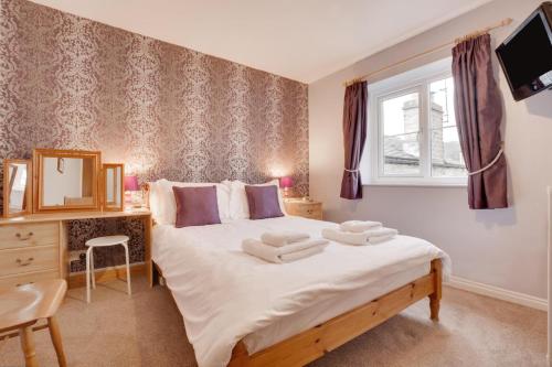 a bedroom with a large bed and a window at 3 Bed in Leyburn oc-ds013 in West Witton