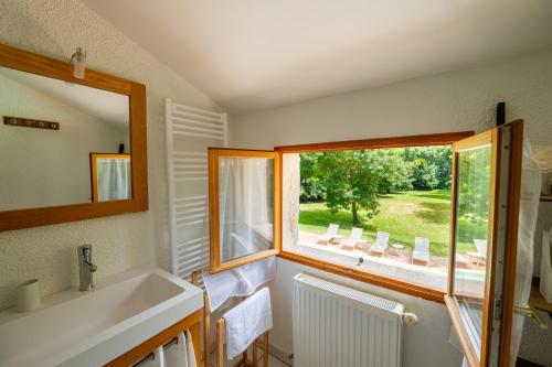 a bathroom with a sink and a window at Gîte le Moulin Samsara in Homps