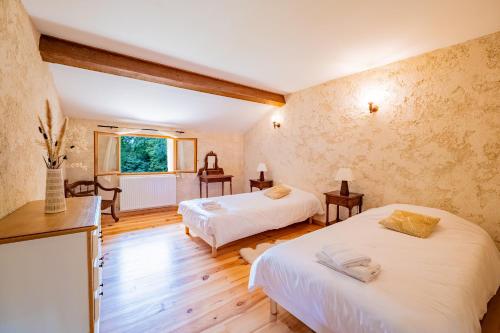 a bedroom with two beds and a window at Gîte le Moulin Samsara in Homps