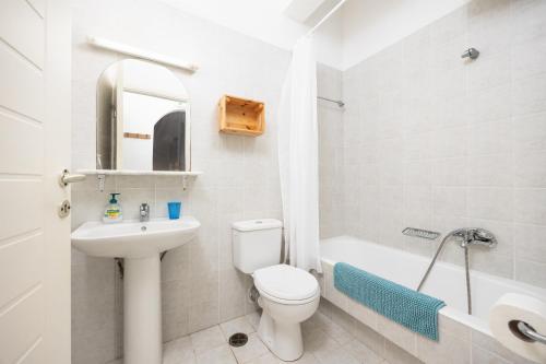 a bathroom with a toilet and a sink and a tub at Villa Calliope Kalamaki in Kalamaki