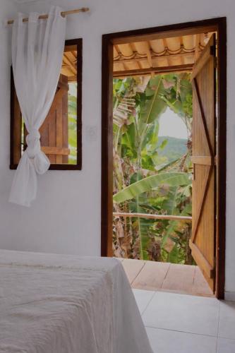 a bedroom with a window with a view of the ocean at Kalena Suítes in Lençóis