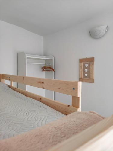 a bedroom with a bed and a white wall at in Piazza in Mezzocorona