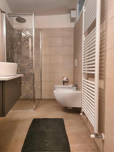 a bathroom with a toilet and a sink and a shower at in Piazza in Mezzocorona