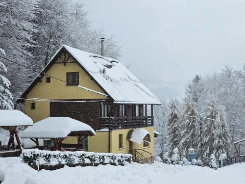 a house with snow on the roof of it at Complex SummerTime in Cavnic