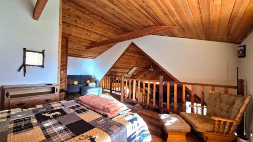 a bedroom with a bed and a wooden ceiling at Guys Getaway Cabin in Ruidoso