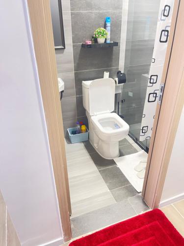 a bathroom with a toilet and a red rug at Naisolas place in Marimbeti
