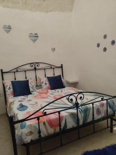 a bedroom with a metal bed with flowers on it at Maison della Madia in Triggiano