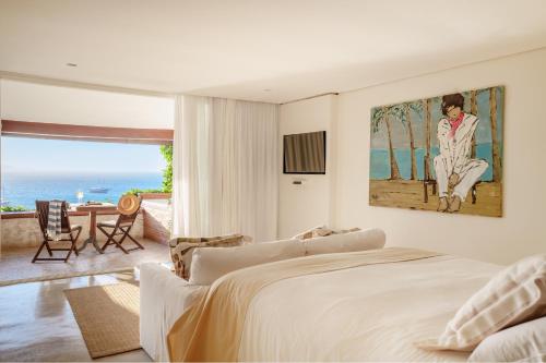 a bedroom with a bed and a view of the ocean at Casas Brancas Boutique Hotel & Spa in Búzios