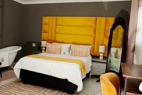 a bedroom with a large bed with a yellow headboard at Siyamthanda Boutique in Louis Trichardt
