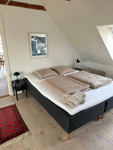 a bedroom with a large bed with white sheets at Havnehuset Kerteminde in Kerteminde