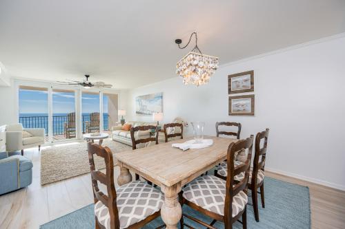 a dining room and living room with a table and chairs at Wind Drift 310S condo in Orange Beach