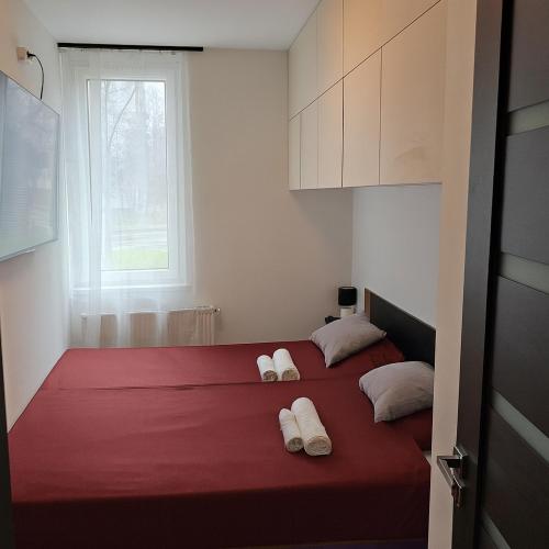 a bedroom with two beds with red sheets and white pillows at Szilvási's Smart Apartman in Eger