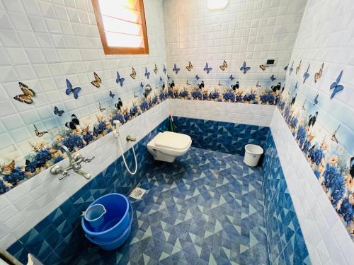 a bathroom with blue and white tiles and a toilet at selvis casa in Pondicherry