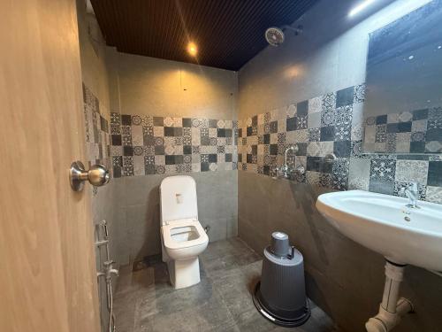 a bathroom with a toilet and a sink at Baga Sea shine in Baga