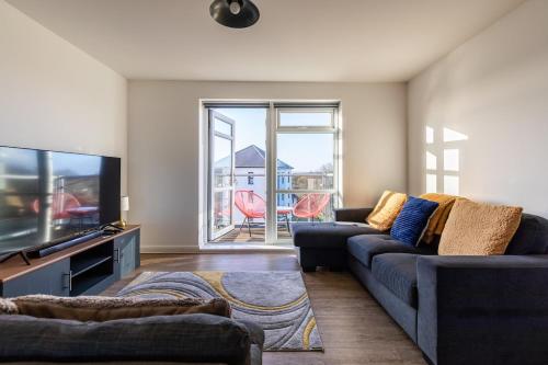 a living room with a couch and a tv at Lane End - Bright & Spacious 2-Bed Flat with Balcony & Parking in Bristol
