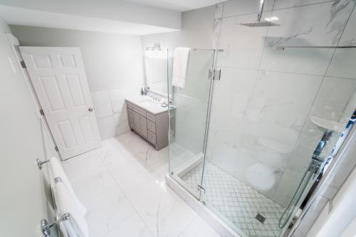 a white bathroom with a shower and a sink at James Buchanan Hotel, Trademark Collection by Wyndham in Mercersburg