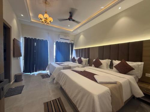 a hotel room with two beds and a chandelier at Baga Sea shine in Baga