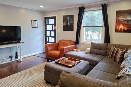 a living room with a couch and a tv at Freshly Renovated Raleigh Home Near Downtown! in Raleigh