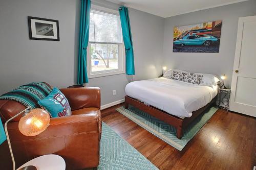 a bedroom with a bed and a couch at Freshly Renovated Raleigh Home Near Downtown! in Raleigh