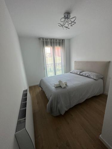 a bedroom with a bed and a chandelier at 60m2 Cozy Apartament in Valencia