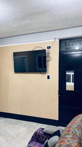 una stanza con una parete con una tv e un divano di hidden house shared apartment a San Juan La Laguna