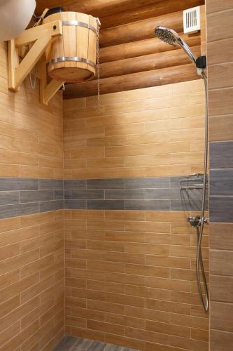 a bathroom with a shower with a shower head at Jugland-Private Riverside Retreat with Sauna & Hot Tub in Bajāri