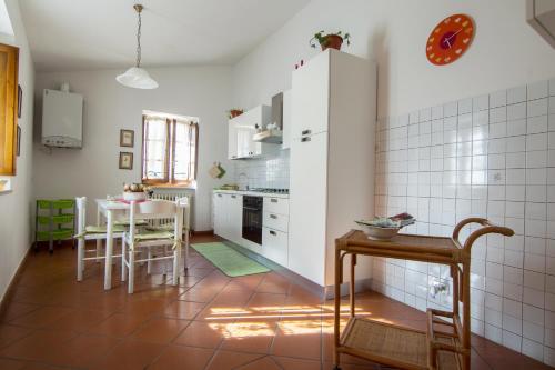 a kitchen with white cabinets and a table at Casa Flora in Spello