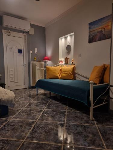 a bedroom with a blue bed and yellow pillows at Isthmus Cuddly Nest in Isthmia