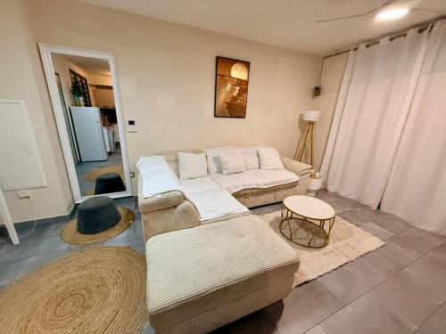 a living room with two couches and a table at Les Douces Nuits Saint Pierre in Saint-Pierre