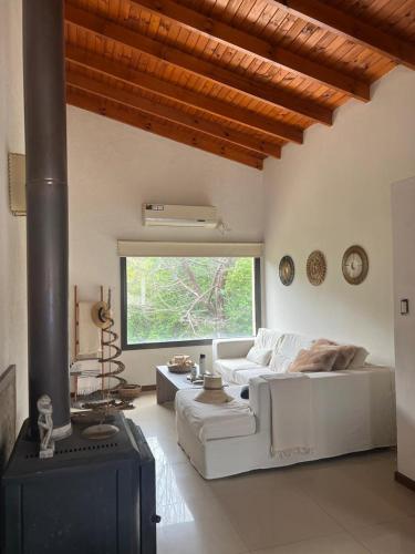 a living room with a white couch and a fireplace at Willert hauss in La Cumbrecita