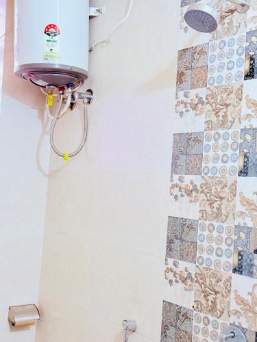 a shower in a bathroom with tiles on the wall at AeroStay Comfort Inn - Near Ranchi Airport in Rānchī
