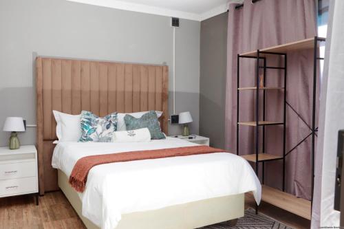 a bedroom with a large bed with a wooden headboard at Siyamthanda Boutique in Louis Trichardt