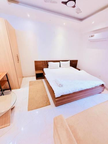 a bedroom with a bed in a white room at AeroStay Comfort Inn - Near Ranchi Airport in Rānchī