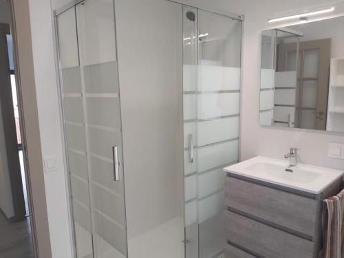 a white bathroom with a sink and a shower at Ca l'Agüela -Fontanars dels Alforins in Fontanares