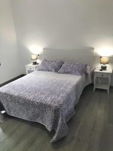 a bedroom with a bed with two lamps on two tables at Ca l'Agüela -Fontanars dels Alforins in Fontanares