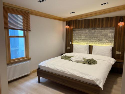 a bedroom with a bed with white sheets and a window at Arkeon Bosphorus Hotel & Suites in Istanbul