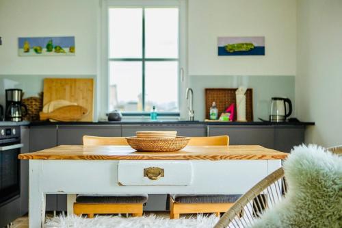 a kitchen with a wooden table and chairs at Reethaus "Buntspecht" in Zierow