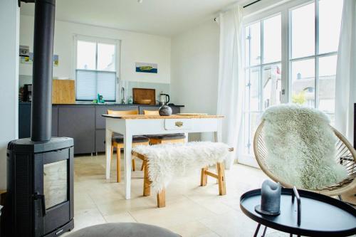 a living room with a fireplace and a table and chairs at Reethaus "Buntspecht" in Zierow
