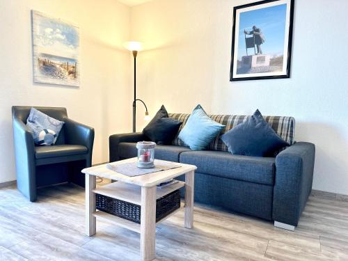 a living room with a couch and a table at Ferienwohnung De Dwarslöper in Dorum-Neufeld