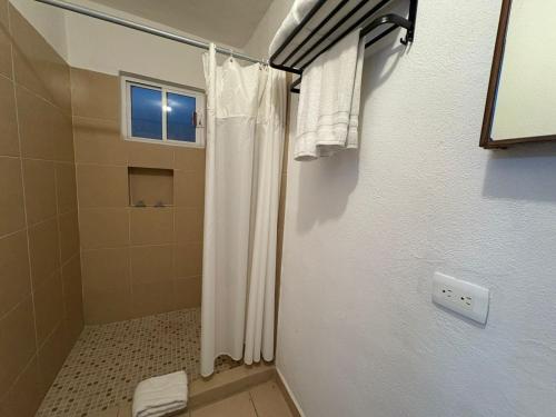 a bathroom with a shower curtain and a window at Hotel Palmeras Los Cabos in Cabo San Lucas